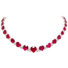 The heart shape ruby and diamond necklace is constituted by 34 faceted rubies of homogeneously brilliant quality, especially cut from larger Mozambique rough to obtain the regular and symmetrical graduation from center to back. The total weight of rubies after cutting is approximately 95 carats. The colored stones are interspersed with diamond motifs set with a total of 7.78 carats of round diamonds of top quality (F/VVS). The neckpiece is one-of-a-kind not only for the difficult matching/cuttin Ruby And Diamond Necklace 1stdibs, Ruby Diamond Necklace Set, Red Ruby Necklace, Riviera Necklace, Ruby Bracelets, Ruby Heart Necklace, Heart Shaped Diamond Necklace, Heart Diamond Necklace, Ruby Necklace Designs