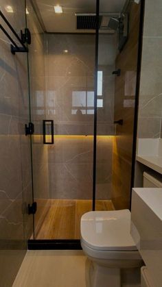 a bathroom with a glass shower door and toilet