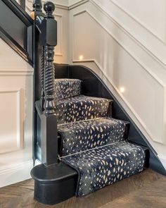 a set of stairs with black and gold patterned carpet