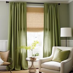 a living room with green curtains and a white chair in front of a large window