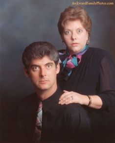 a man and woman posing for a photo in front of a blue background with the image of them looking at the camera