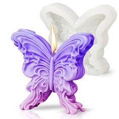 a candle that is shaped like a butterfly with purple and white wings on it's body