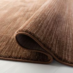 a close up view of a brown rug on the floor with white floors and walls