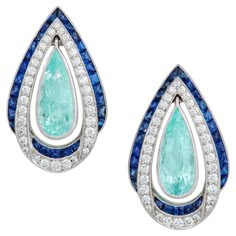 Notice how the Paraiba Tourmaline are attached to allow movement and interest while being surrounded by Ceylon Blue Sapphires and diamonds. Handmade in 18 Karat White Gold. These earrings are one of a kind and were designed and created alongside a coordinating ring in a separate listing. Earring Details: (2) Paraiba Tourmaline Weighing 2.70 Carats (70) Round Brilliant Diamonds Weighing 1.50 Carats (44) French Cut Sapphires Weight 2.30 Carats Total Gem Weight 6.50 Carats Width 5/8" Length 1" Over American Art Deco, Gold Chandelier Earrings, Fine Jewelery, Tourmaline Earrings, Paraiba Tourmaline, Sparkly Jewelry, French Cut, Art Deco Diamond, Fine Jewels