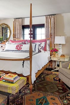 a bedroom with a canopy bed and colorful rugs on the floor in front of it