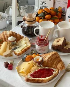 an assortment of cheeses, jams and bread on a table