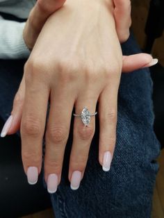 a woman's hand with a diamond ring on it