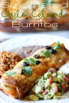 an enchilada is on a plate with rice and beans