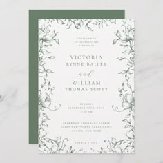 a wedding card with green and white flowers on the front, in an elegant frame