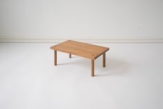 a small wooden table sitting on top of a white floor