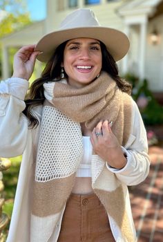 a woman wearing a tan hat and scarf