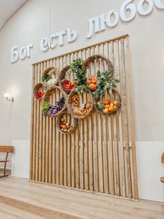 a wooden bench sitting in front of a wall with baskets filled with fruits and vegetables