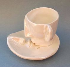 a white coffee cup and saucer with an elephant on it