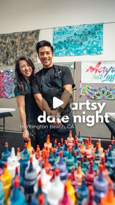 two people standing next to each other in front of arty date night signs and bottles