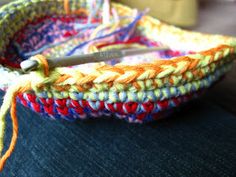 a crocheted basket with scissors in it