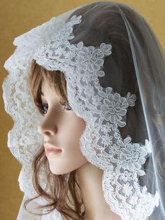 a mannequin wearing a veil with lace on it