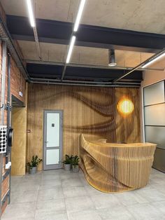 an office lobby with a curved wooden counter and planters on the wall, next to a door