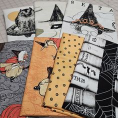 four different halloween themed napkins on a table with spiderwetches and witches