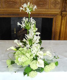 a bouquet of flowers sitting on top of a table next to a fire place in a room