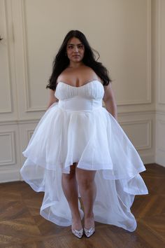 a woman in a white dress posing for the camera