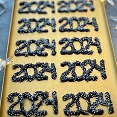 the numbers are made out of black beads and plastic bead caps on a wooden board