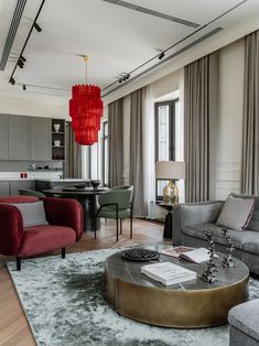 a living room filled with furniture and a red chandelier