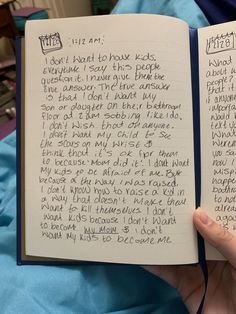 an open notebook with writing on it in someone's hand next to a bed