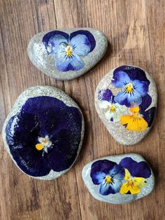 three rocks with flowers painted on them