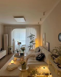 a living room filled with furniture and lots of plants on top of the couches