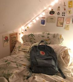 a backpack sitting on top of a bed in a room with lights strung above it