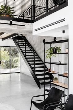 an open living room with stairs leading up to the second floor