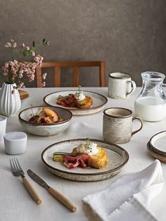 a table topped with plates and cups filled with food