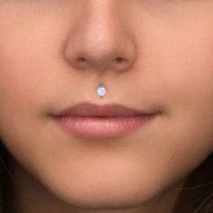 a close up of a woman with a nose ring on her nose and the bottom part of her nose