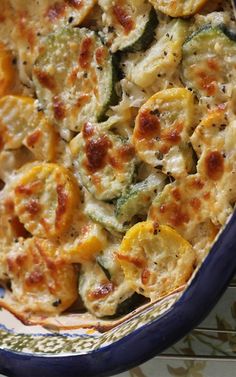 a casserole dish with zucchini, cheese and other vegetables in it