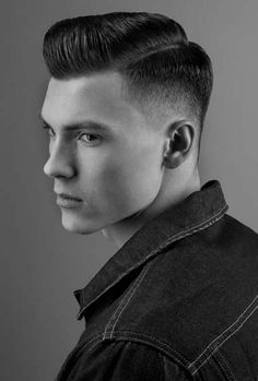 a black and white photo of a young man with short hair wearing a denim jacket