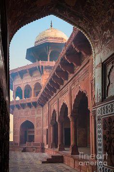 an archway leading to a building with a dome in the middle and pillars on either side