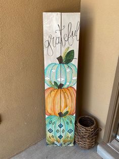 a painted wooden sign that says grateful with pumpkins