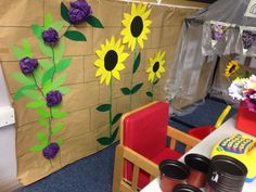 a classroom with sunflowers painted on the wall and plastic cups in front of it