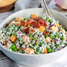 a white bowl filled with peas and bacon