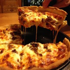 a person taking a slice of pizza from a pan