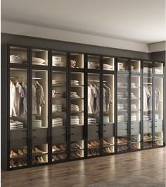 a walk in closet filled with lots of clothes and shoes next to a wooden floor