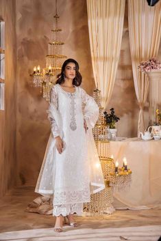 SKU:- 2305 Price for Shirt and inner only. This enchanting white creation is crafted from intricately cutwork and meticulouslythreaded fabric, enriched with delicate organza and adorned with exquisite pearls,crystals, and meticulously handmade vibrant flowers. The ensemble can becomplemented with a dupatta, fashioned from luxurious pure organza, featuringfour-sided tassels and meticulous threadwork that collectively bestow a regal allure. Model wearing shirt length 45 inch Maria B Lawn, Organza Suits, Pakistani Dresses Online, Embellished Shirt, Organza Sleeves, Lawn Dress, Pakistani Salwar Kameez, Maria B, Lawn Suits