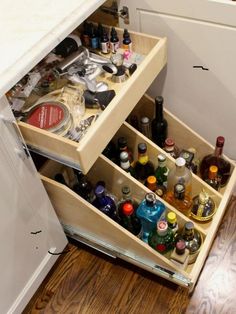 an open drawer in a kitchen filled with bottles