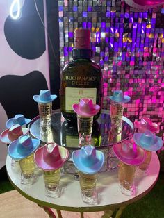 a table topped with lots of glasses and bottles next to a wall covered in sequins