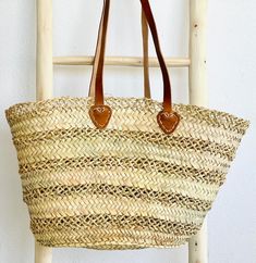 This sturdy Large Lace Straw Market Basket is handwoven from natural palm leaves for a unique and beautiful boho chic look. Its classic lace style and ancestral craftsmanship make it perfect for a farmers market haul or a day at the beach. Each basket is crafted with skill by female artisans. dimensions: height: 14", width: 19", base: 6" x 11" // 35cm H, 48cm W, 15*28cm baseleather strap: 10" high // 25cm style:two different styles of handles: braided or plain leather*because each basket is hand Beach Purse, Morocco Style, Boho Purse, Lace Bag, Market Basket, Straw Basket, Market Baskets, Boho Purses, Market Tote