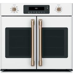 the double oven is white with gold trimmings and features two large, dual doors