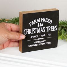 a hand holding a small black and white christmas tree card