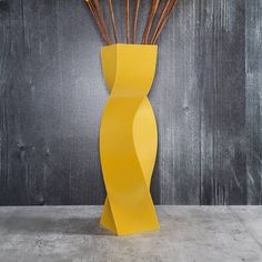 a yellow vase with sticks sticking out of it