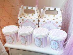 four ice cream containers sitting on top of a counter next to a pink and white box