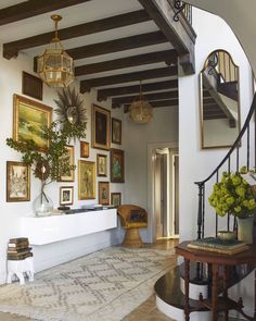 the inside of a house with pictures on the wall and stairs leading up to the second floor